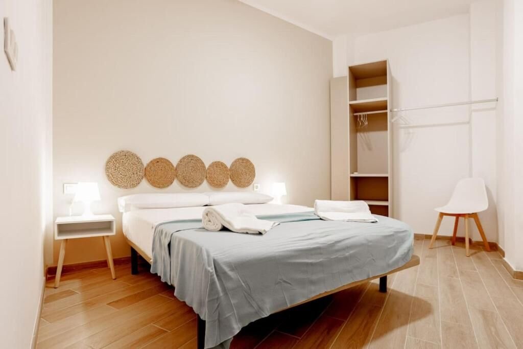Dormitorio con cama de matrimonio, armario abierto y toallas de cortesía
