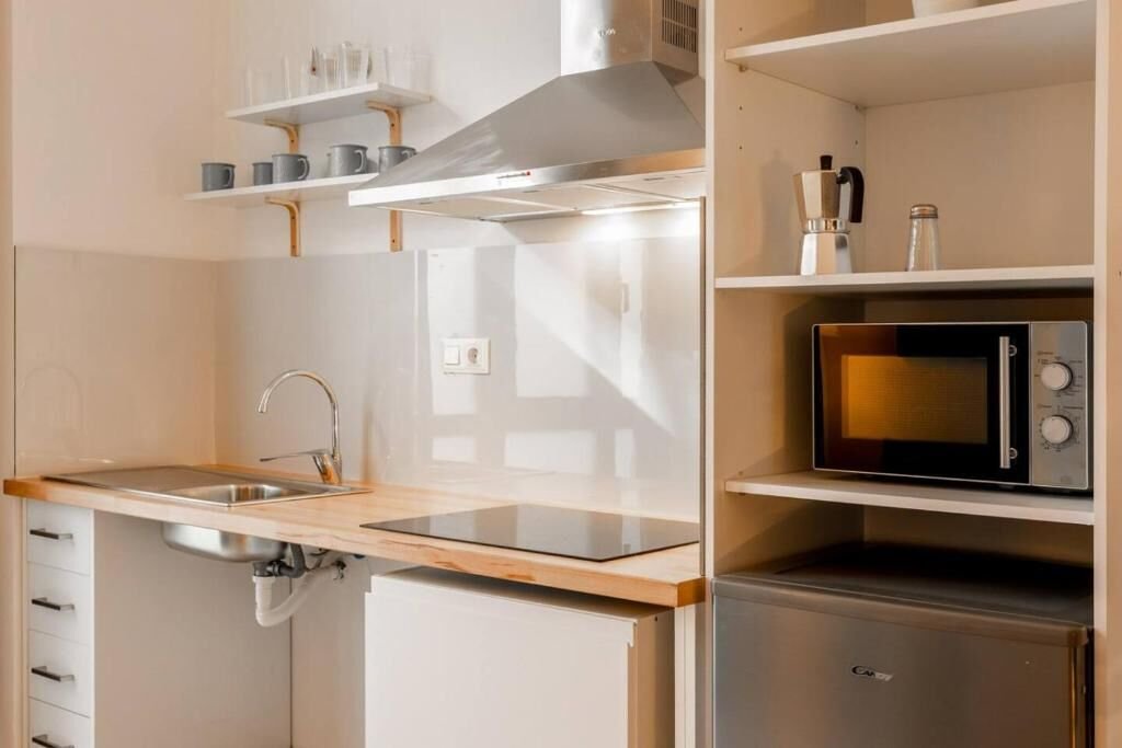 Detalle de la cocina: encimera, fregadero, vitrocerámica y microondas