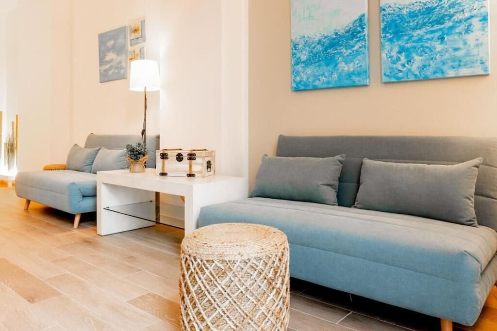 Zona de estar con dos sofás y cuadros de inspiración marina