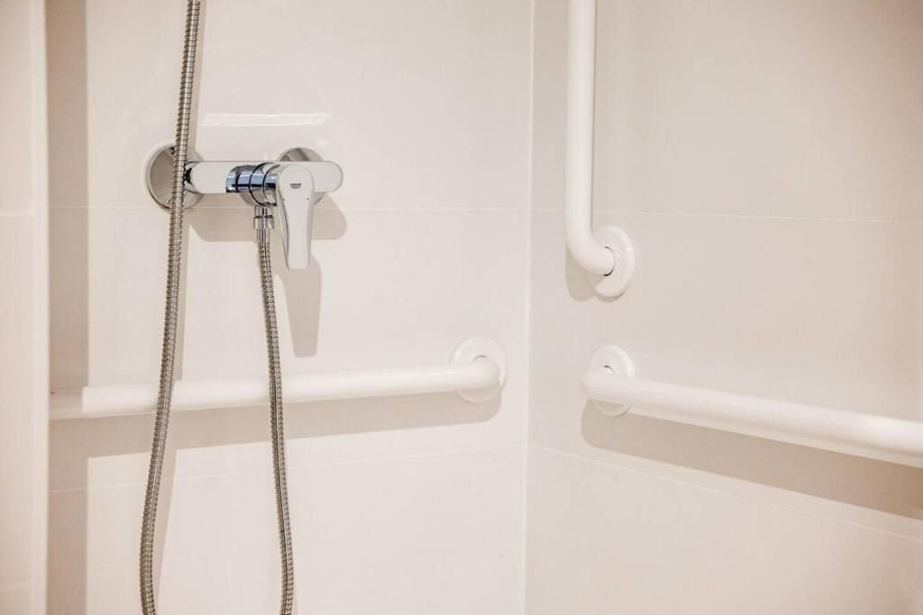 Ducha con barras de apoyo en el baño adaptado