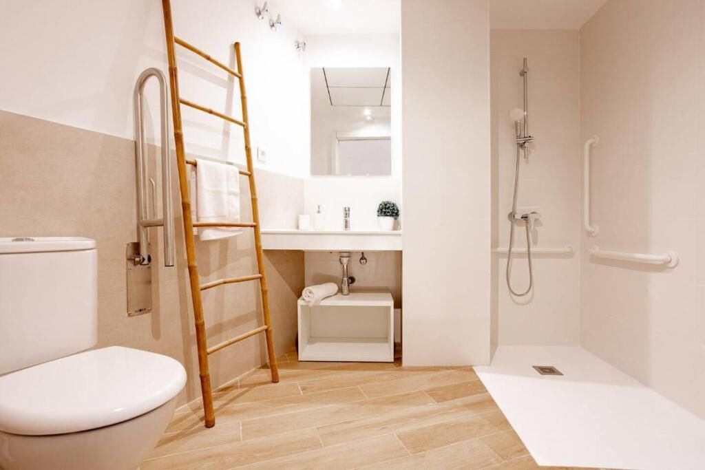 Ducha a ras de suelo con barras de apoyo en el baño