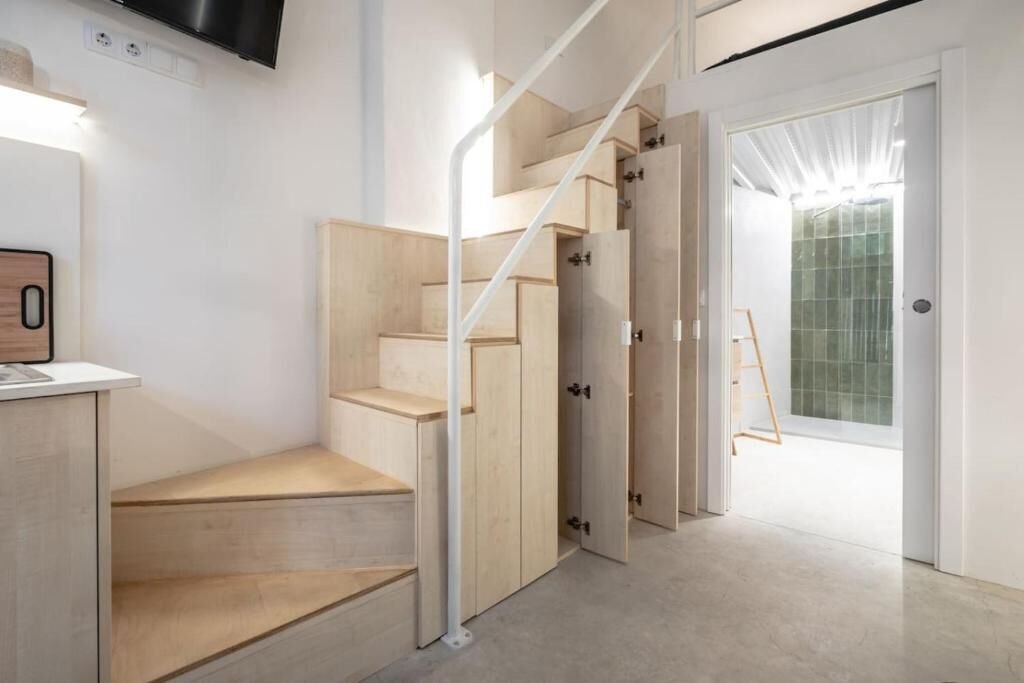 Armarios bajo la escalera junto a la puerta del baño con azulejo verde