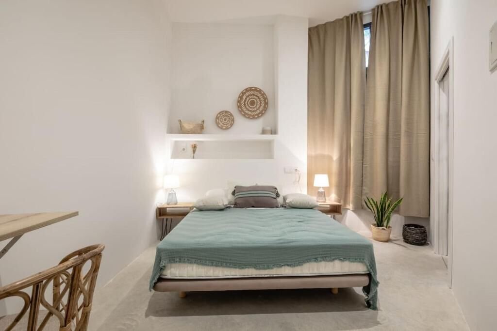 Dormitorio en el altillo con cama y mesillas, bajo el techo abuhardillado
