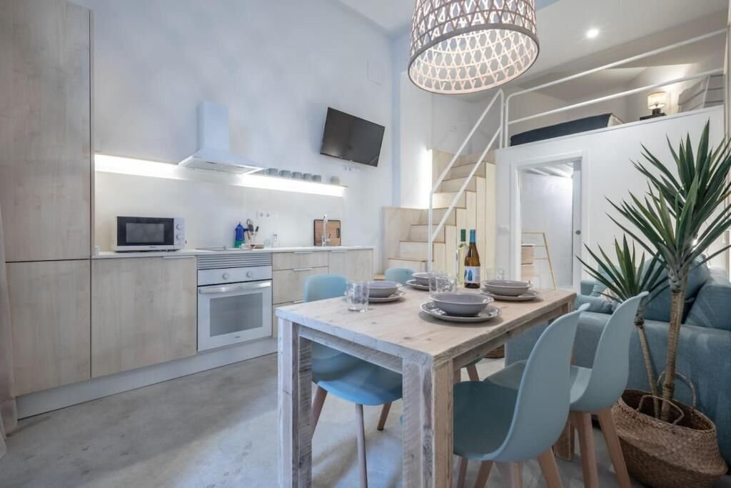 Cocina equipada con horno, microondas y mesa de comedor con sillas