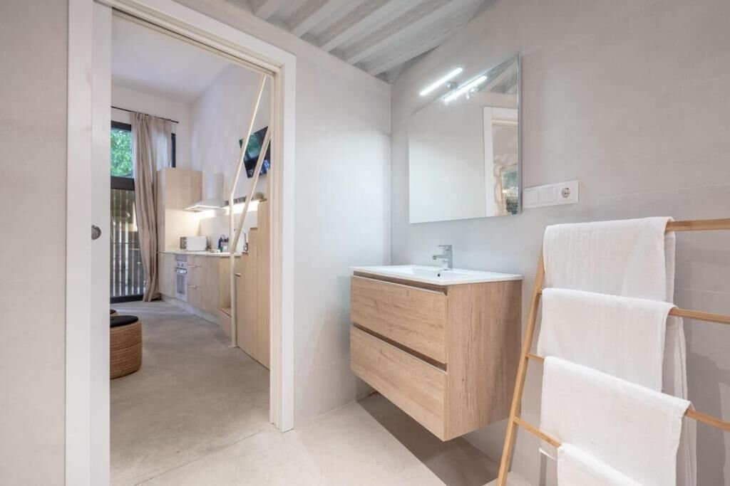 Lavabo de madera con espejo, junto al acceso a la cocina